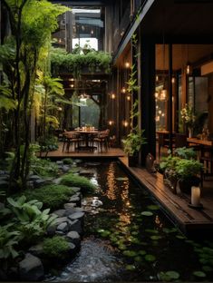 an outdoor dining area is lit up by string lights and surrounded by greenery, along with a small pond