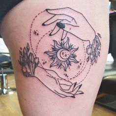 two hands touching each other with the sun and moon above them on a woman's thigh