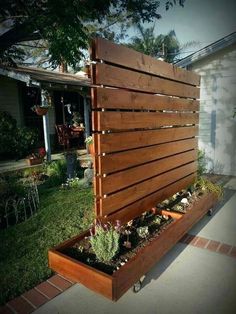 a wooden planter with succulents in it on the side of a house