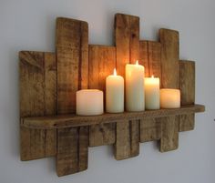 several candles are lit on a wooden shelf