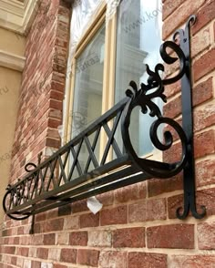 an iron railing on the side of a brick building with a window in the background