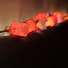 a row of red and white lights sitting on top of a black table next to each other