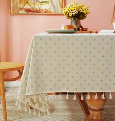 a dining room table with a white and blue polka dot table cloth on top of it