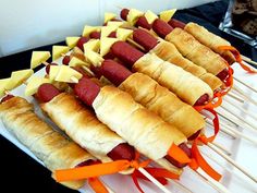 hot dogs and cheese on skewers with orange ribbons