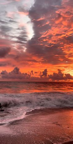 the sun is setting over the ocean with waves coming in