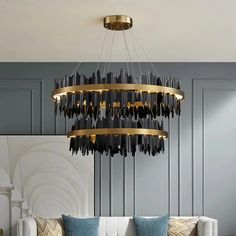 a modern chandelier hanging from the ceiling over a couch in a living room