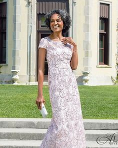 a woman in a pink dress is standing on the steps and smiling at the camera