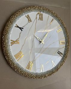 a clock with gold and white roman numerals on it's face is shown