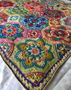 a colorful crocheted blanket on top of a bed