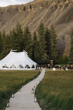 a path leading to a white tent in the mountains