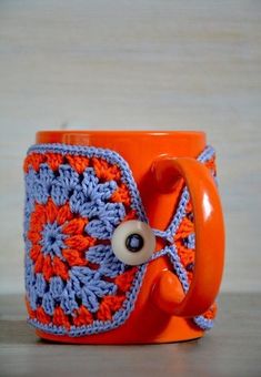 an orange and blue crocheted coffee cup holder