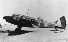 an old black and white photo of a fighter plane on the ground with two men standing next to it