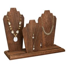 three wooden jewelry stands with necklaces on them