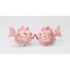 two pink ceramic fish figurines sitting side by side