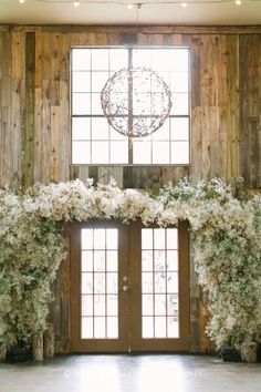 a room with two windows and some flowers on the wall