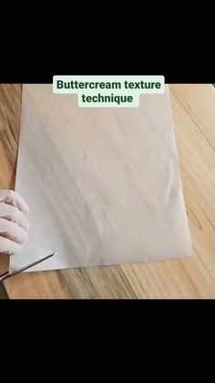 a person in white gloves cutting paper with scissors on a wooden table and the words buttercream texture technique above it