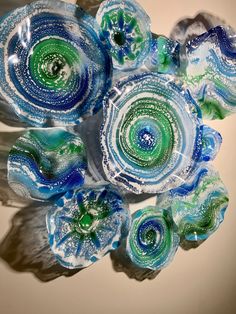 blue and green glass flowers sitting on top of a table