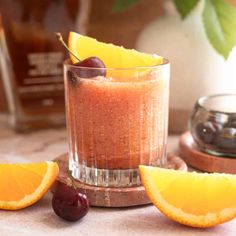 an orange and cherry smoothie with cherries on the side