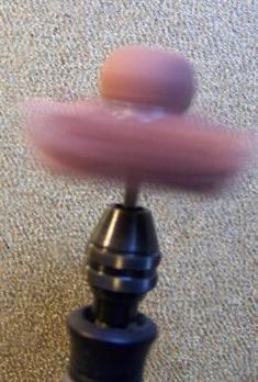 an object is spinning around on the floor in front of a carpeted area with a rug