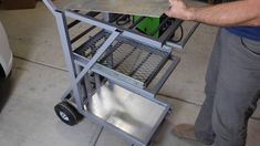 a man is working on a metal cart