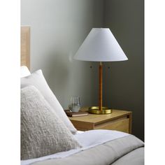 a lamp on a nightstand next to a bed