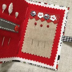 a close up of a piece of cloth with buttons and pins in the shape of a heart