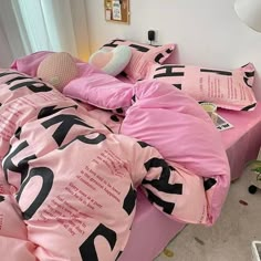 a bed covered in pink sheets and pillows