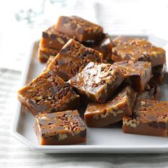 a white plate topped with pieces of chocolate fudges on top of a table