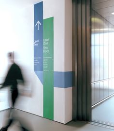 a blurry photo of a man walking past a sign that says exit through the floor