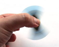 a hand is pressing the button on a white surface