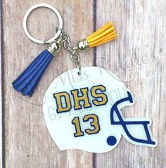 a keychain with a football helmet and tassell on the front that says dhs 13