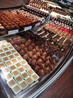 a display case filled with lots of different types of chocolates and candies on top of each other