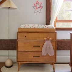 a baby's crib in the corner of a room next to a lamp