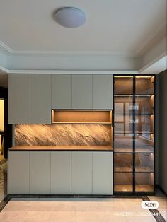 an empty kitchen with white cabinets and marble counter tops