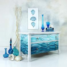 a blue and white dresser with sea shells on it