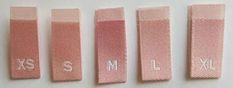 four pink hair clips with the letters s, m, and l on each side