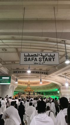 a group of people in white robes standing under a sign that reads safa start