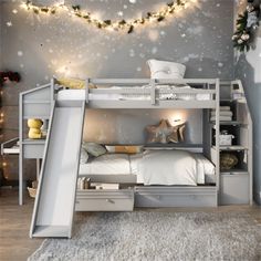 there is a bunk bed with a slide next to it and christmas lights on the wall