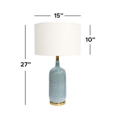 a blue table lamp with a white shade on it's side and measurements for the base