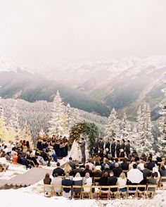 a wedding ceremony in the mountains with snow on the ground and people sitting at chairs