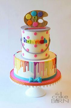 a three tiered cake decorated with colorful icing