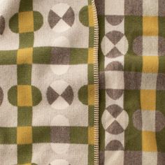 the fabric is green, yellow and white with circles on it's edges that are overlapping