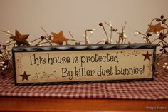 a sign that says this house is protected by killer dust bunnies on a table