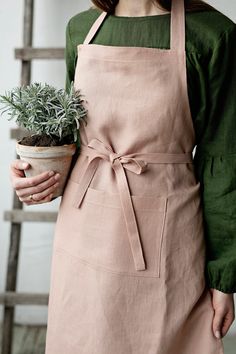 Traditional apron is made from 100% soft and washed linen. Details: - Colour: Dusty rose - Composition: 100% Oeko-Tex certified linen - One large pocket - Adjustable with button - Size: One size - Medium weight linen - Linen care: machine wash gentle; tumble dry low, ironing optional - The price is for one apron, other pictured items are not included Apron Photoshoot Ideas, Apron Photoshoot, Apron Photography, Kitchen Apron Design, Apron Woman, Embroidery Branding, Farm Apron, Traditional Aprons, Apron Women