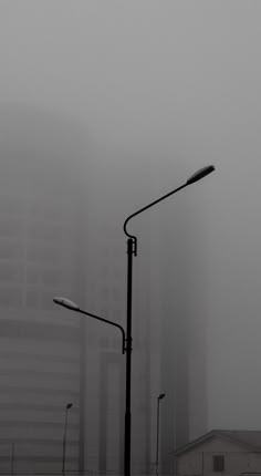 a street light on a foggy day with buildings in the background