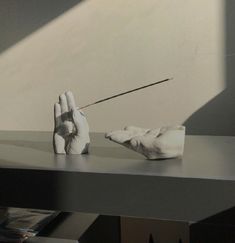 a hand holding a stick on top of a table