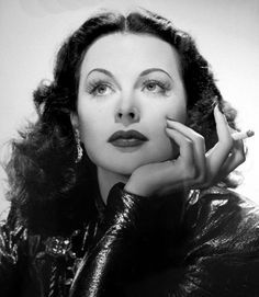 an old black and white photo of a woman with her hand on her chin looking up