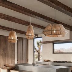 a kitchen with wooden beams and hanging lights over the counter top, along with stools