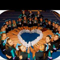 a group of cheerleaders standing in front of a heart made out of hot dogs