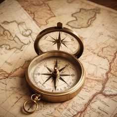 a compass sitting on top of a map next to a pair of gold - toned scissors